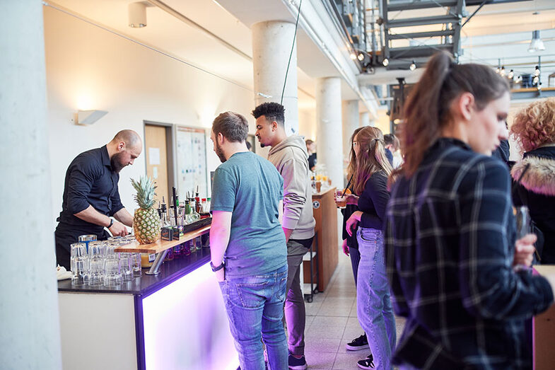 People standing at a counter at the work exhibition/graduation ceremony at the Faculty of Architecture