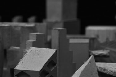 Black and white close-up of the building sculptures cast from fine-grain concrete. The sculptures are reminiscent of skyscrapers and buildings.