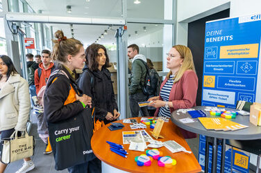 Zwei Studierende bei einem Gespräch mit einer Unternehmensvertreterin auf dem Business Event 2023.