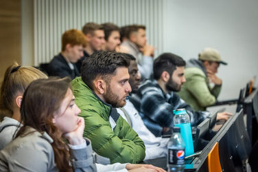 Students sit in a lecture hall.