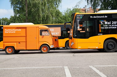 The Citroën HY stands opposite a large city bus from the Dortmund public utility company. The bus is advertising the Open Day at Fachhochschule Dortmund.