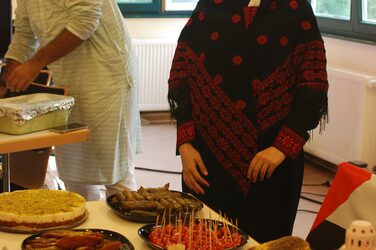 Studierende an einem Tisch mit Essen am palästinensischen Kulturstand.