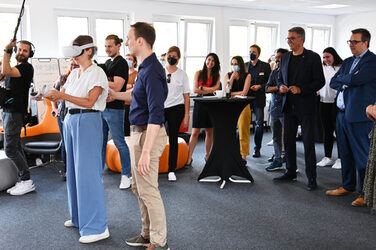 Woman with VR glasses and controllers in her hands in front of an audience