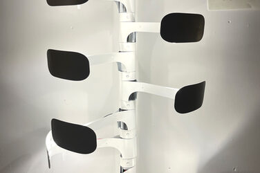 Eine Lampe aus weißem Metall mit mehreren beweglichen Leucht-Armen.