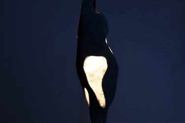 Night shot of an illuminated, sculptural pendant luminaire with generatively manufactured elements