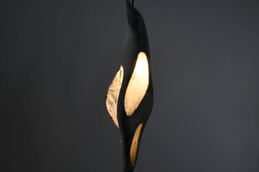 Night shot of an illuminated, sculptural pendant luminaire with generatively manufactured elements