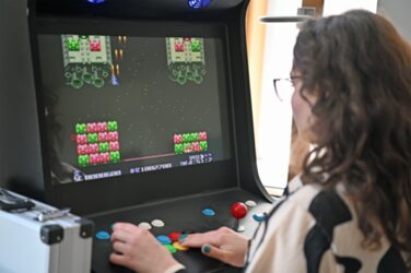 A person plays a computer game on a self-built slot machine at Fachhochschule Dortmund.