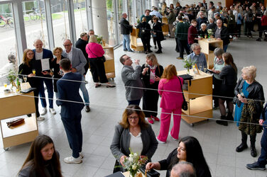 Blick ins Foyer des Fachbereichs mit den Absolvent*innen und deren Familie und Freunden beim Sektempfang und Buffet nach der Veranstaltung.