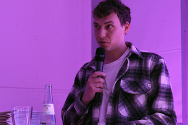 Graduate Sascha Becker during his speech at the lectern in the lecture hall.