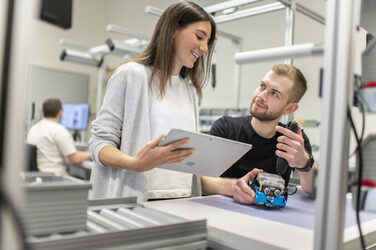 Eine wissenschaftliche Mitarbeiterin erklärt einem Studenten etwas zu dem Demonstrationsprodukt im Lean Labor.