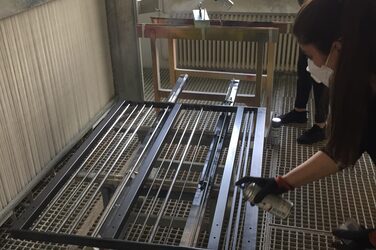 Students paint their railings with black spray paint.