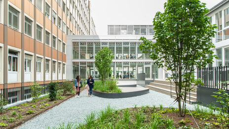 Foto vom Innenhof bei den studentischen Arbeitsplätzen an der Sonnenstraße. Im Innenhof laufen zwei Frauen.