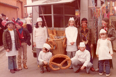 Dressed-up children stand in front of the HY, which is still silver-gray at the time. Some of the children are holding baked goods towards the camera.