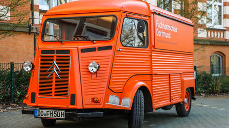 Der orangefarbene Citroen HY steht vor dem FH-Hauptgebäude an der Sonnenstraße.