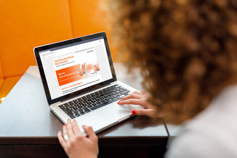 Foto über die Schulter einer Studentin auf einen Laptop, auf dem der Job-Newsletter der Fachhochschule Dortmund aufgerufen ist.__A femal student is sitting on her laptop on which the job newsletter of the Dortmund University of Applied Sciences is called.