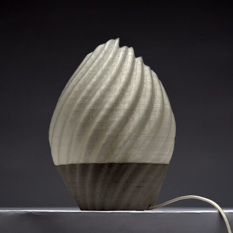 Model of a shell-like curved luminaire with generatively manufactured lampshade in beige against a gray background