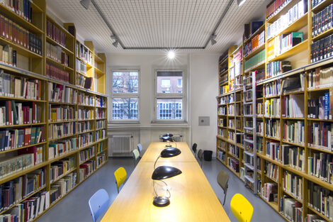 Photo of the library reading room with book shelves, desks, reading lamps and chairs__Photo of the library reading room with book shelves, desks, reading lamps and chairs