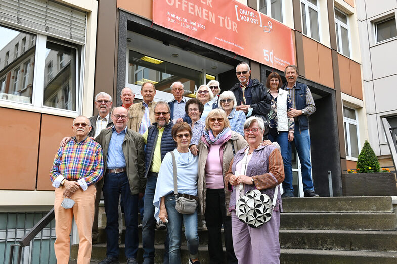 Eine Gruppe Menschen steht auf den Stufen vor dem Haupteingang der FH Dortmund.