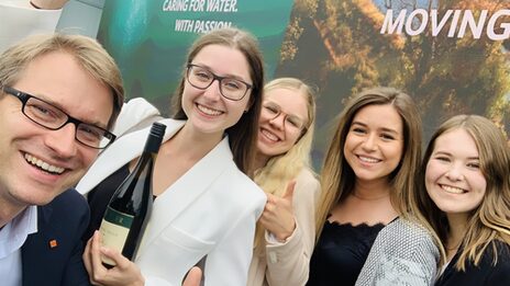 Das Gruppenselfie zeigt fünf jubelnde Personen nebeneinander.