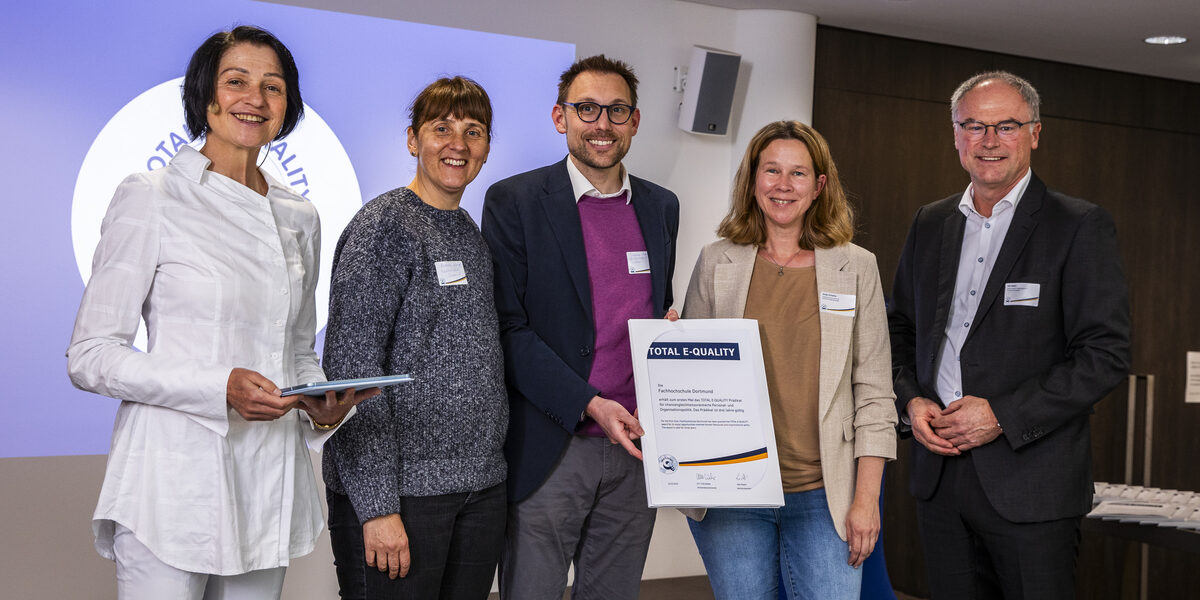 People stand on the stage and hold a certificate