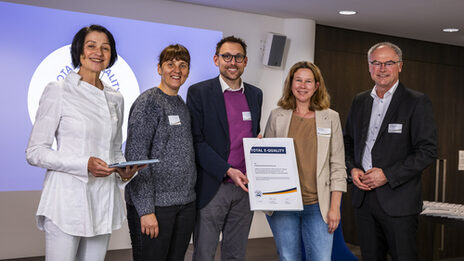 People stand on the stage and hold a certificate