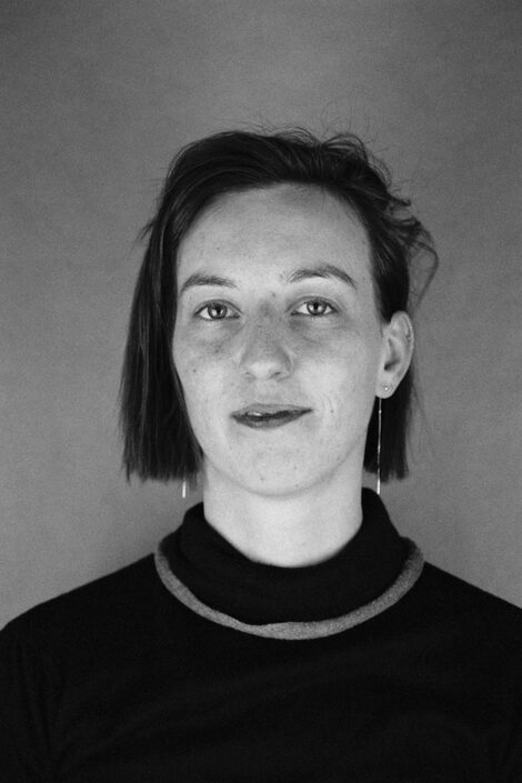 Black and white portrait of a person with chin-length hair and a dark top.