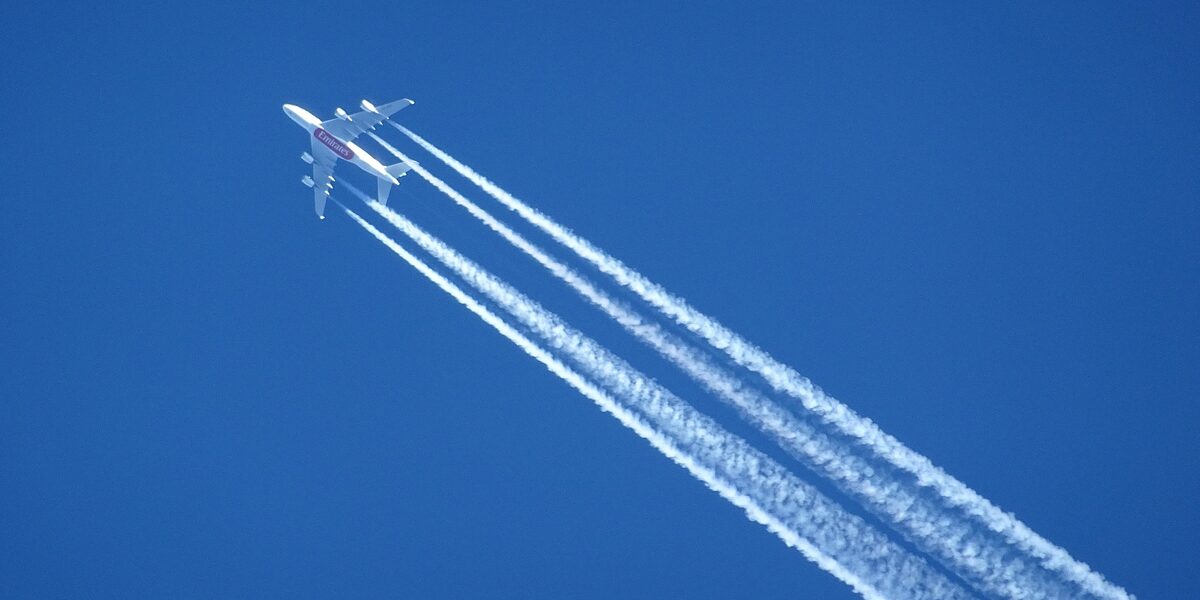 An airplane and its contrails can be seen in the sky.