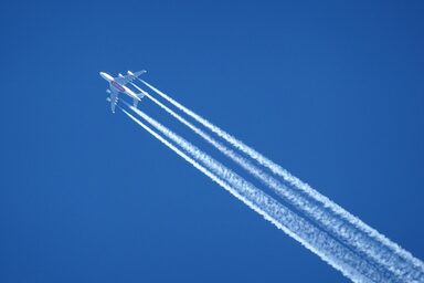 An airplane and its contrails can be seen in the sky.