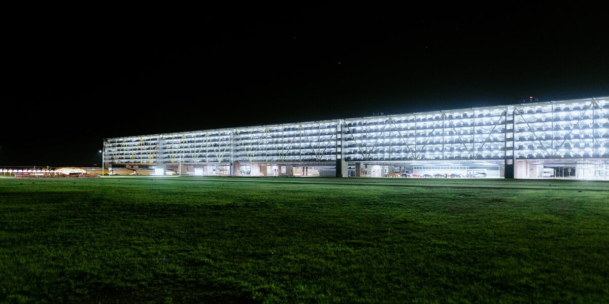 In der Nacht leuchtet ein stark erhelltes Parkhaus.