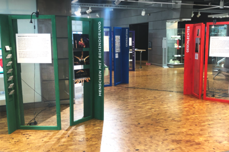 Colored and partially transparent exhibition elements on the topics of gender, people with disabilities and generations are located in one hall.