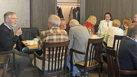 People sit at tables and talk.