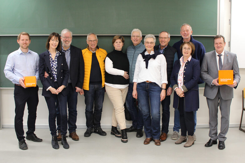 Several people are standing in front of a blackboard.