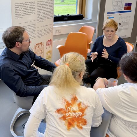 Four people are sitting together and talking.