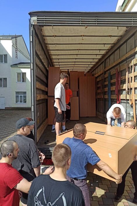 Furniture is unloaded by helpers in Ukraine