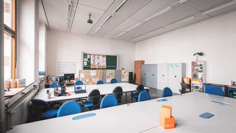 Photo of a room with several tables arranged next to each other.