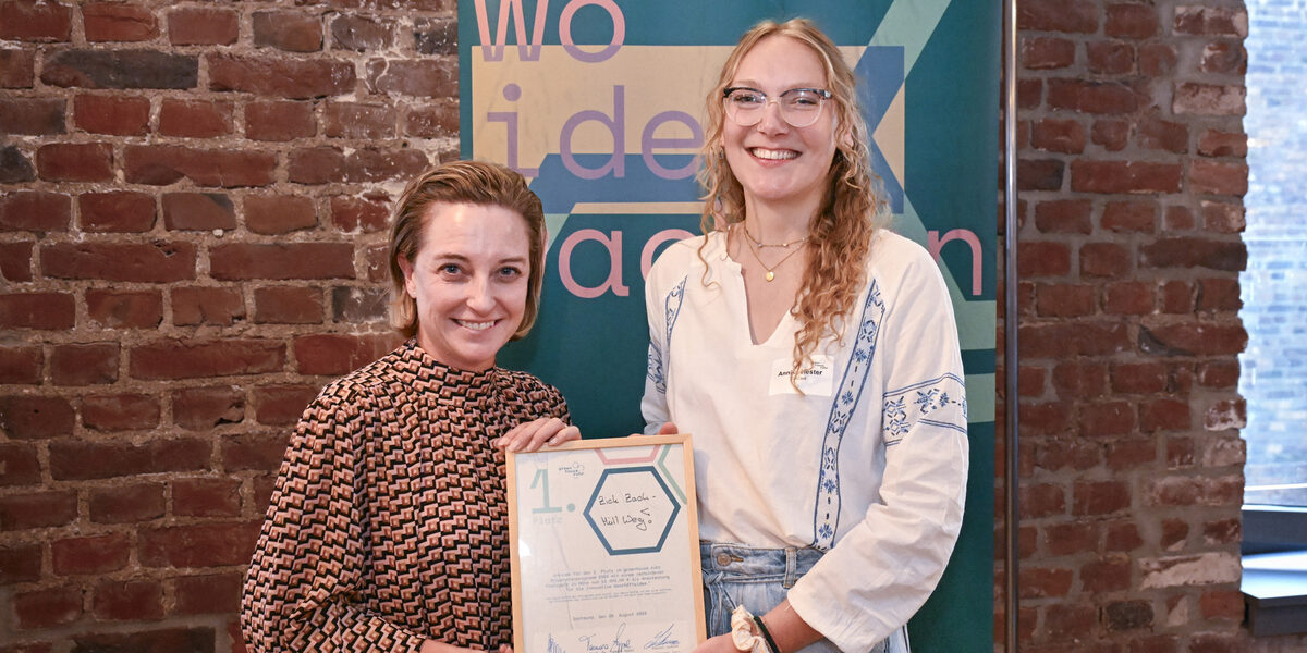 Two people holding a framed certificate.