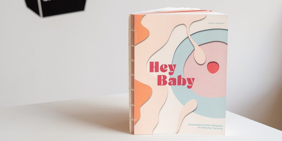 Cover des Hey Baby-Ratgebers mit Titel „Hey Baby“ und Untertitel „Schwangerschafts-Ratgeber in einfacher Sprache“ unzeigt die Befruchtung einer Eizelle