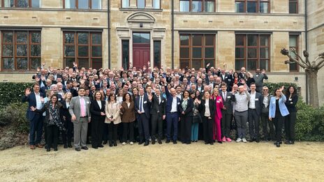 A large group of people are standing in front of a building.