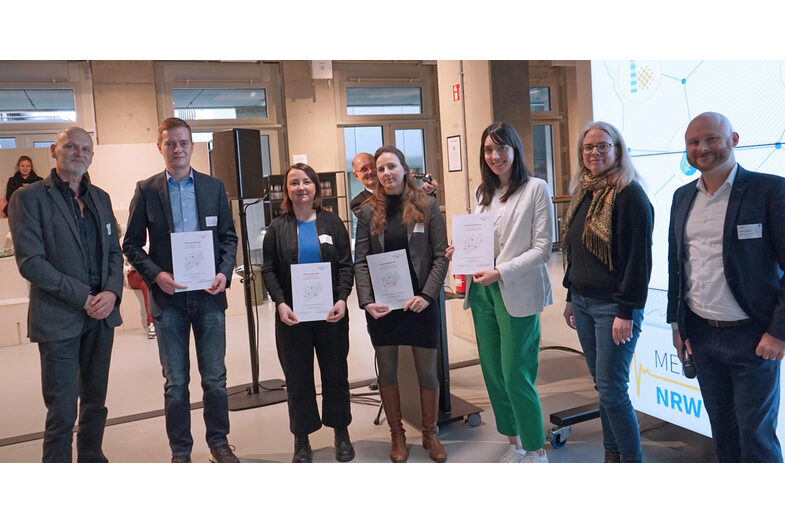 A group of people, some of them holding certificates.