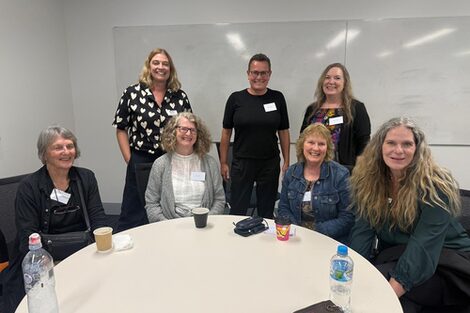 Nicole Tigges gemeinsam mit Kolleg*innen der Partneruni UWA bei einem Symposium in Sydney an einem Tisch.