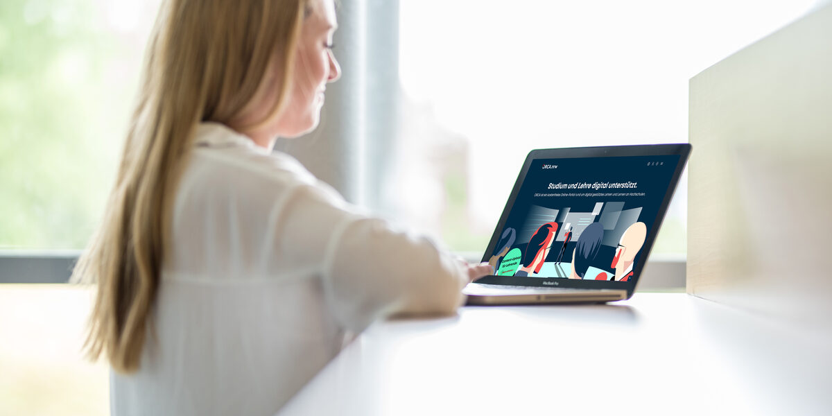 Eine Studentin sitzt vor einem Laptop, dieser zeigt die Startseite des Landesportals ORCA.nrw.