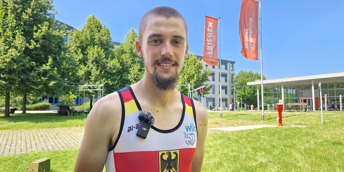 One person is dressed in a Germany jersey and is standing on a green area.