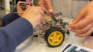 Schüler*innen bauen an einem Modelauto.