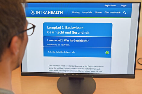 Eine Person schaut auf einen Monitor auf dem die Intrahealth-Website zu sehen ist.