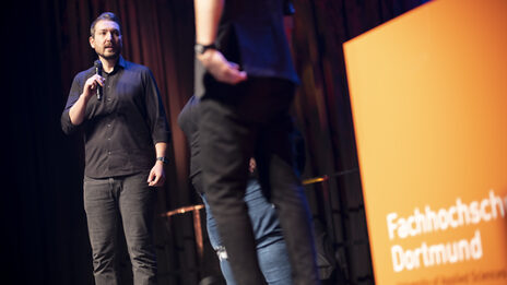 AStA-Vorstand Mehmet Karul auf einer Bühne