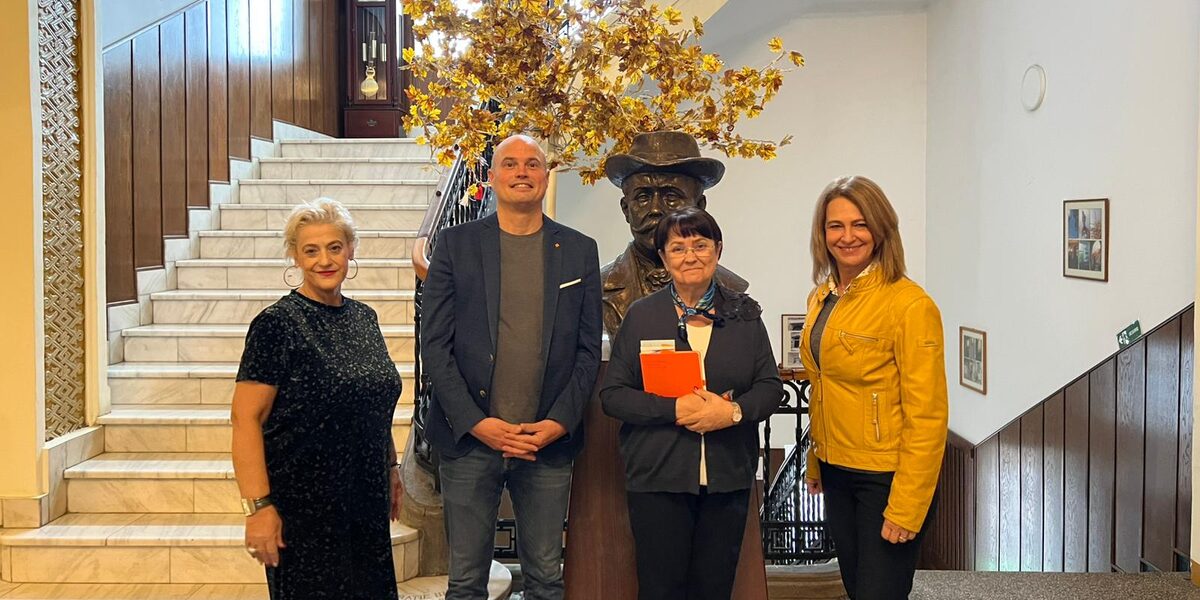 Four people are standing in a prestigious stairwell.