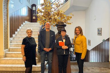 Four people are standing in a prestigious stairwell.