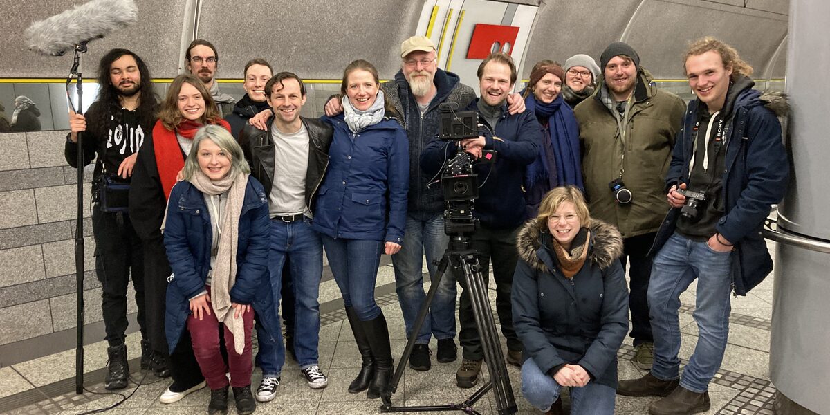 Gruppenbild in einer U-Bahn-Station mit Kamera-Stativ und Mikrofon-Angel