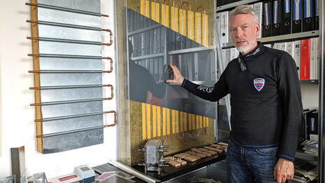 A man stands in an office and explains something.