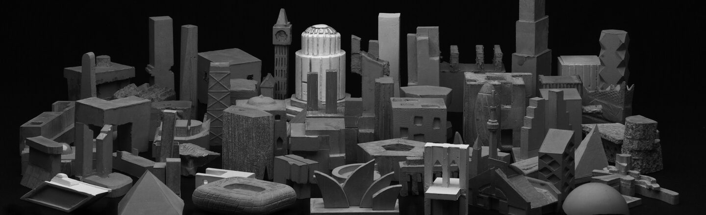 Black and white general view of the filigree concrete sculptures as a result of the "miniature architecture" exercise. The composition of the sculptures is reminiscent of a city. The individual sculptures depict buildings and landmarks.